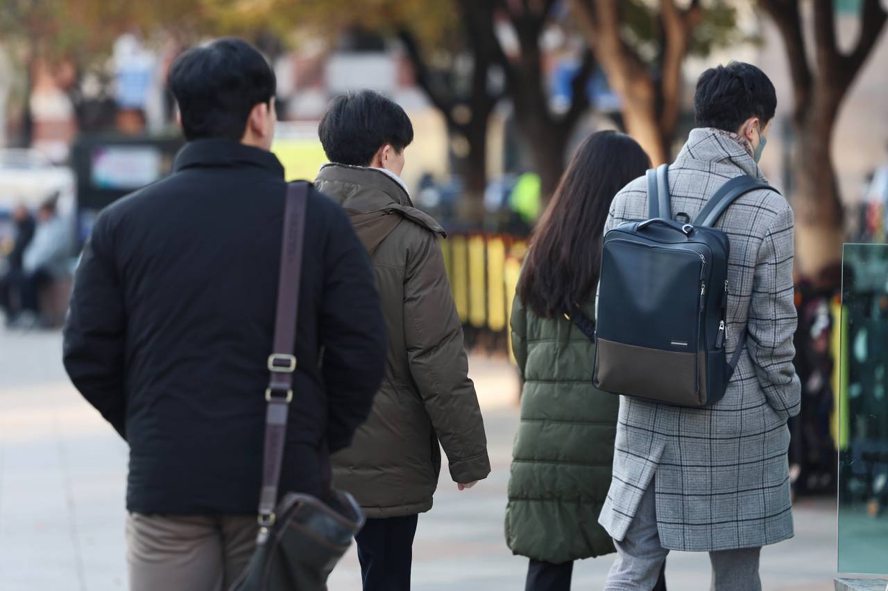 Passersby walk in winter jackets at Gwanghwamun Square in Seoul on Nov. 20. (Yonhap)