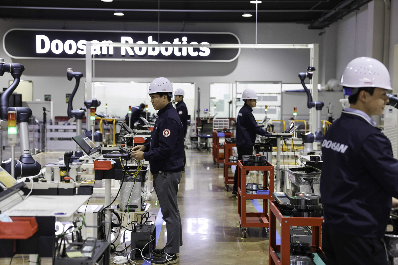 Engineers at Doosan Robotics work on collaborative robots in the company's workshop in Suwon, Gyeonggi Province, conducting extensive 13-hour tests that simulate a variety of scenarios. (Doosan Robotics)