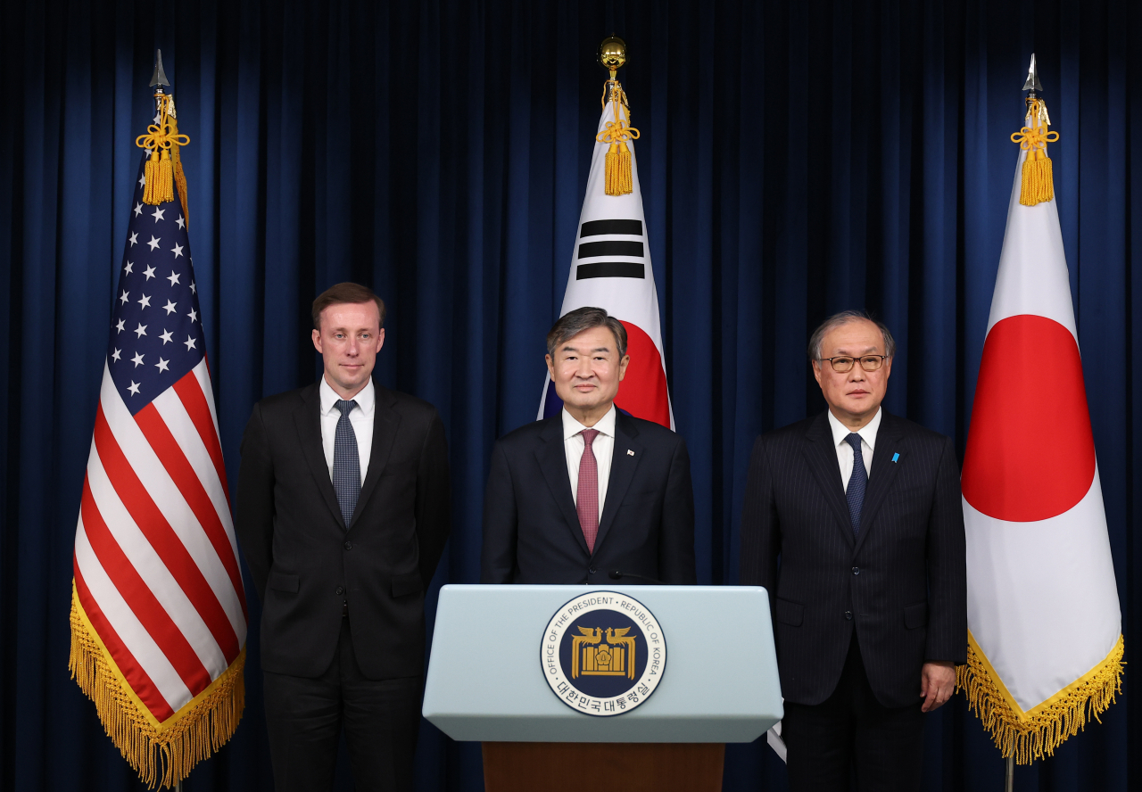 National Security Adviser Cho Tae-yong (center) poses for a photo with US National Security Adviser Jake Sullivan (left) and Japan's National Security Secretariat Secretary General Takeo Akiba in the press briefing room of the presidential office in Seoul on Dec. 9, 2023. (Yonhap)