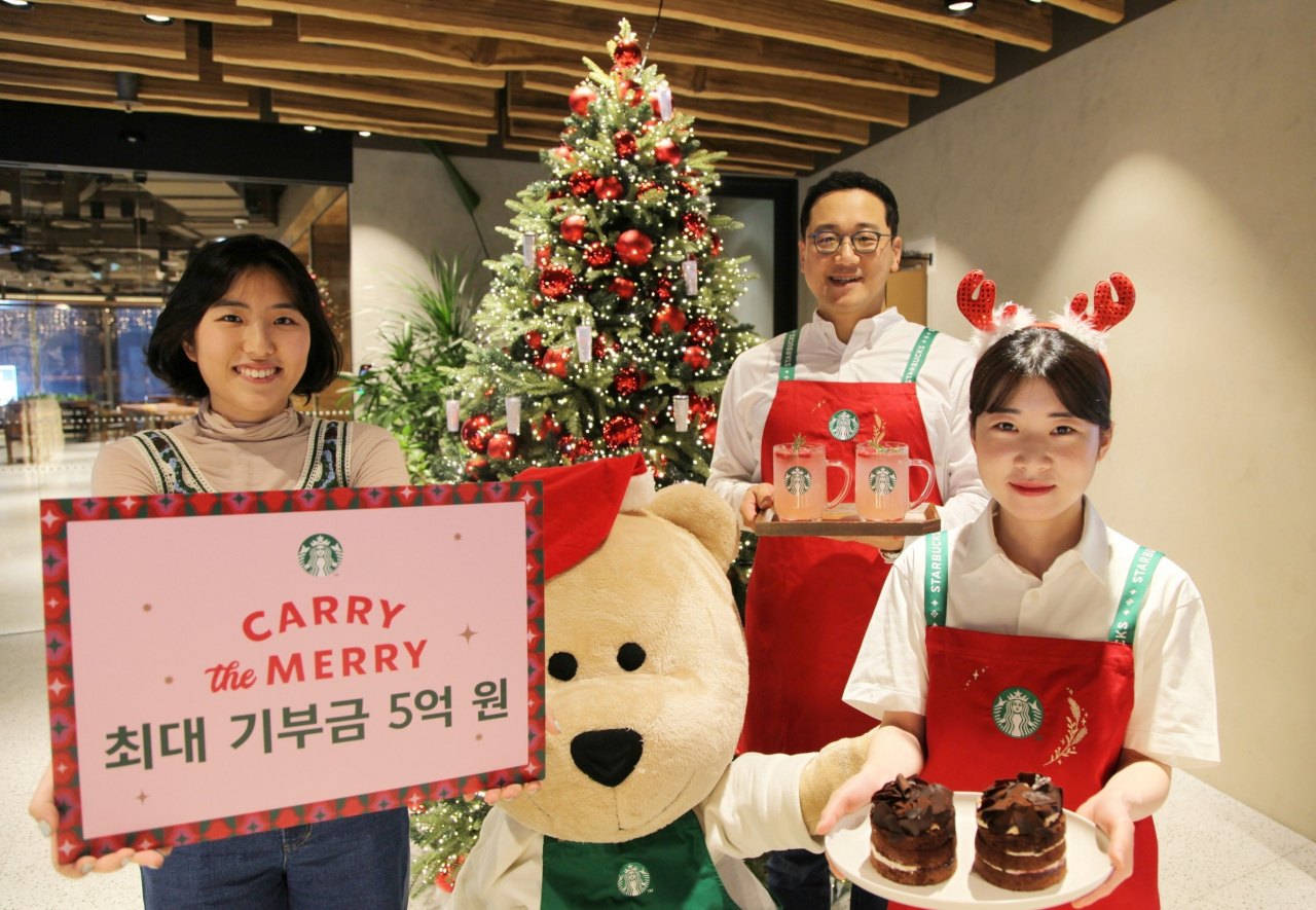 Employees of Starbucks Korea pose for a photo for the company's year-end fundraiser campaign at its Myeong-dong branch in Seoul, Monday. (Starbucks Korea)