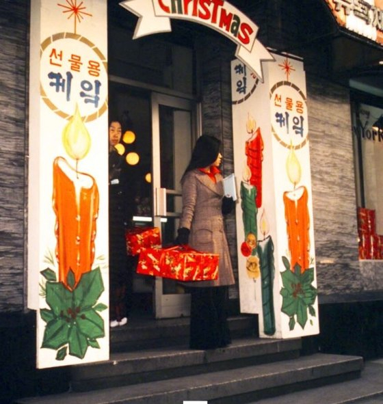 Customers hold boxes of Christmas cakes on Christmas Eve in Seoul in 1975. (Courtesy of National Archives of Korea)