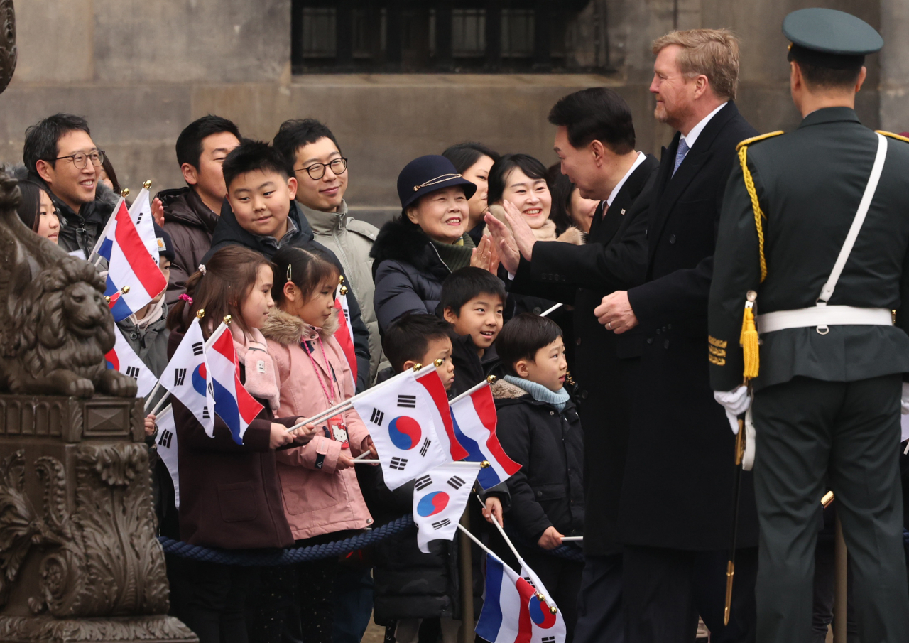 President Yoon Suk Yeol (third from right) and King Willem-Alexander (second from right) greet a group of overseas Koreans after an inspection of the Dutch guard of honor as part of a welcome ceremony at Dam Square in Amsterdam, Tuesday. (Yonhap)