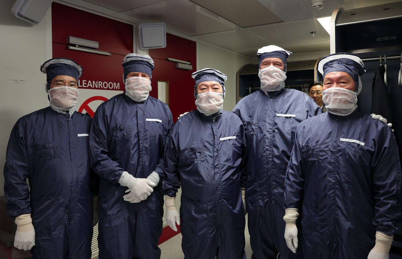 From left: Samsung Electronics Chairman Lee Jae-yong, King Willem-Alexander of the Netherlands, South Korean President Yoon Suk Yeol, ASML CEO Peter Wennink and SK Group Chairman Chey Tae-won pose in dust-free suits as they began touring of ASML's cleanroom at the company headquarters in Veldhoven, the Netherlands, on Tuesday. (Yonhap)