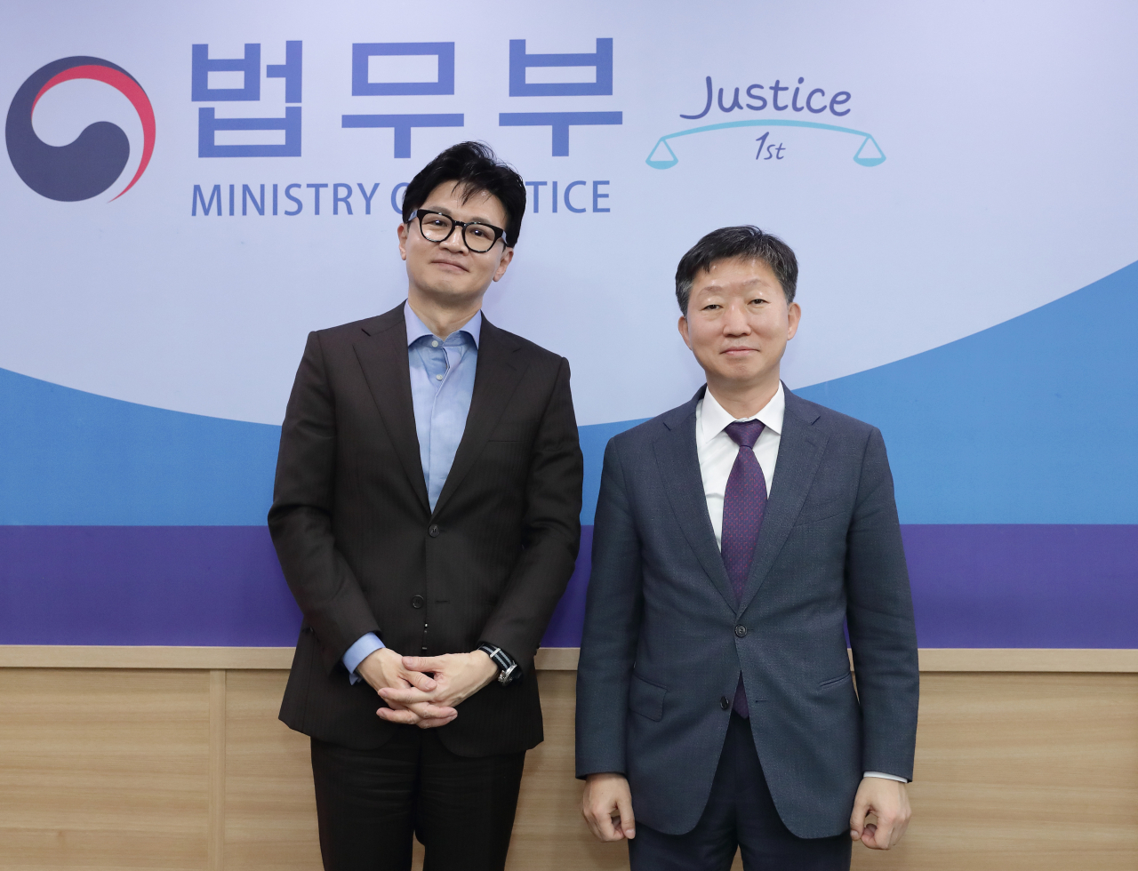 Justice Minister Han Dong-hoon, left, and Migration Research & Training Centre Director Woo Byong-yol poses for a photo at the government complex in Gwacheon, Gyeonggi Province in November. (Yonhap)