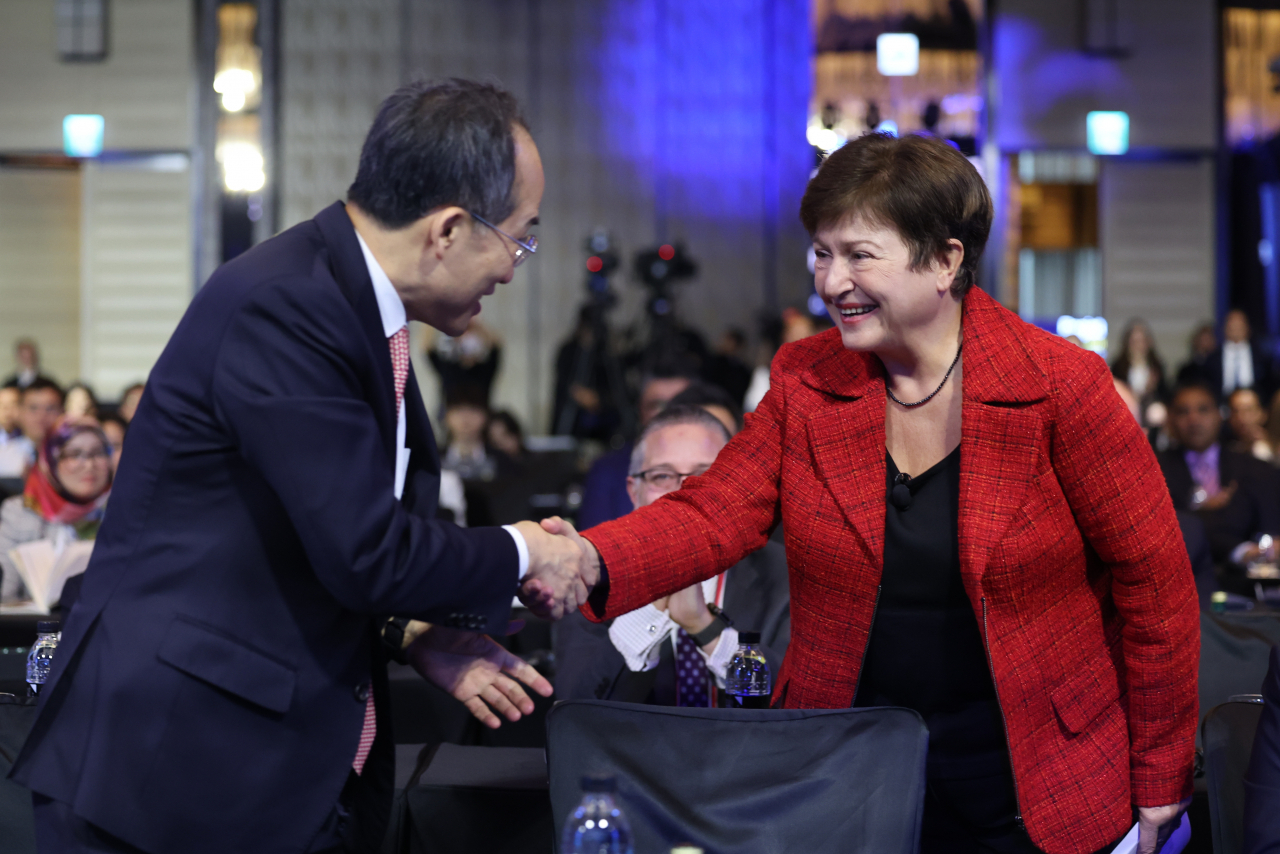 South Korean Finance Minsiter Choo Kyung-ho (left) and International Monetary Fund Chief Kristalina Georgieva shake hands during an international conference at a Seoul hotel on Thursday. (Yonhap)