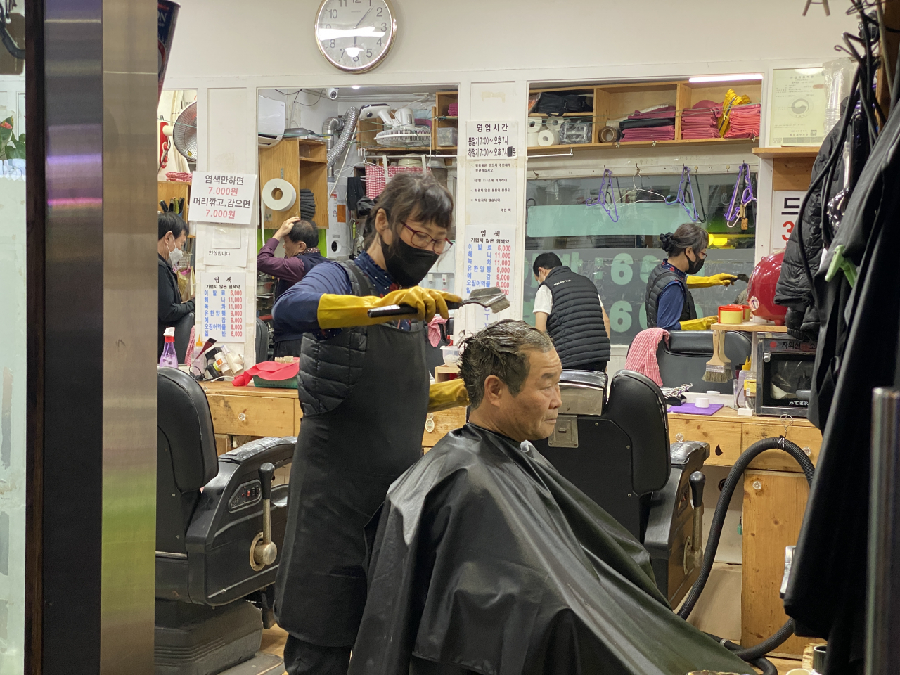 A customer gets his hair dyed at a barbershop in Nakwon-dong, central Seoul, Tuesday. (Hwang Joo-young/The Korea Herald)