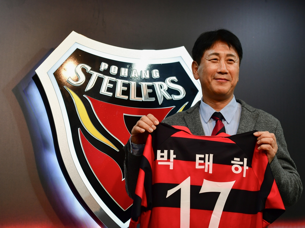 Park Tae-ha, new head coach of Pohang Steelers, poses with his old shirt for the K League club on Friday. (Yonhap)