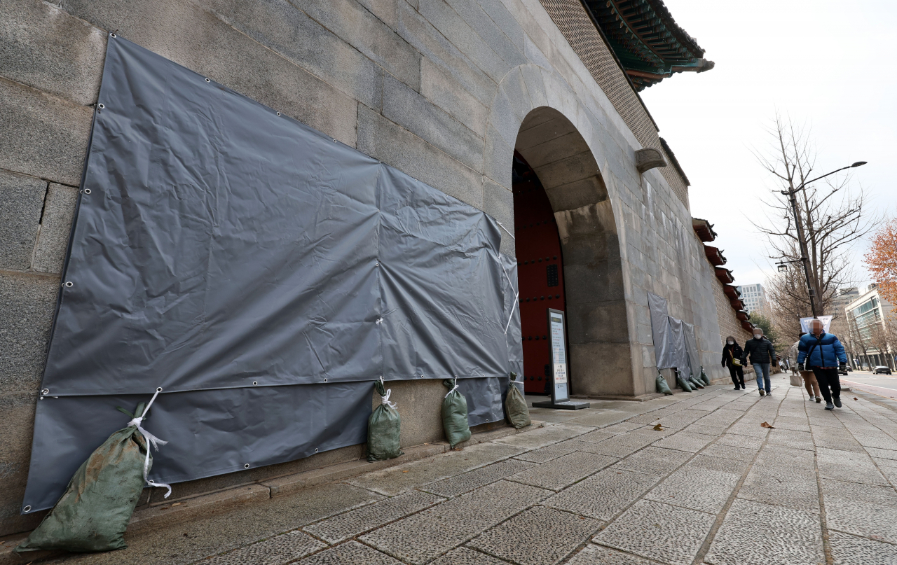 Graffiti sprayed on the walls of Gyeongbok Palace in central Seoul has been temporarily covered up by officials on Saturday. (Yonhap)