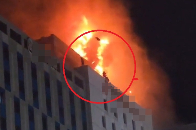 People try to escape a hotel in flames in Incheon on Sunday. (Yonhap)