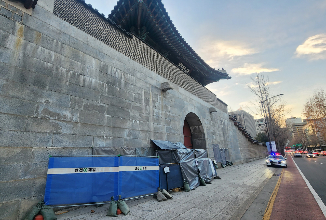 Part of the left wall of the Yeongchumun, the west gate of Gyeongbokgung in Jongno-gu, central Seoul, is covered up to hide graffiti, Monday. (Yonhap)