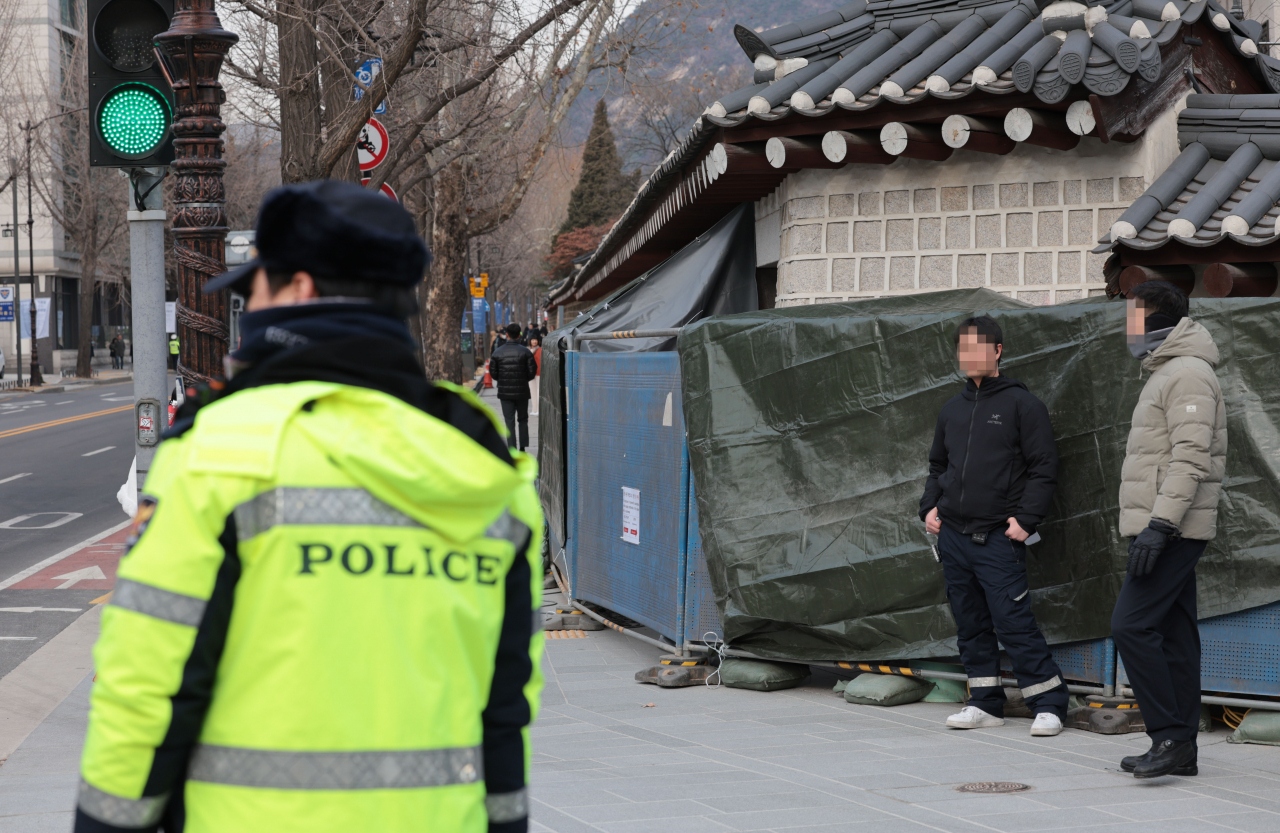 Police officers stand guard near the walls of Gyeongbokgung in Jongno-gu, central Seoul on Tuesday. (Yonhap)