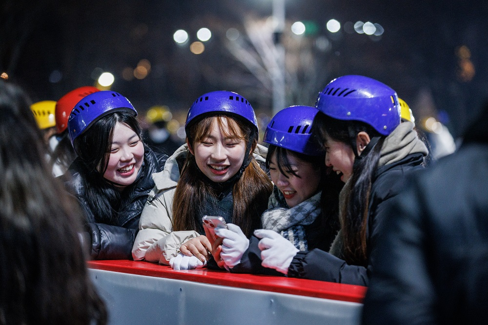Participants review photos as they enjoy the Seoul Plaza Ice Skating Rink in central Seoul. (Seoul Sports Council)