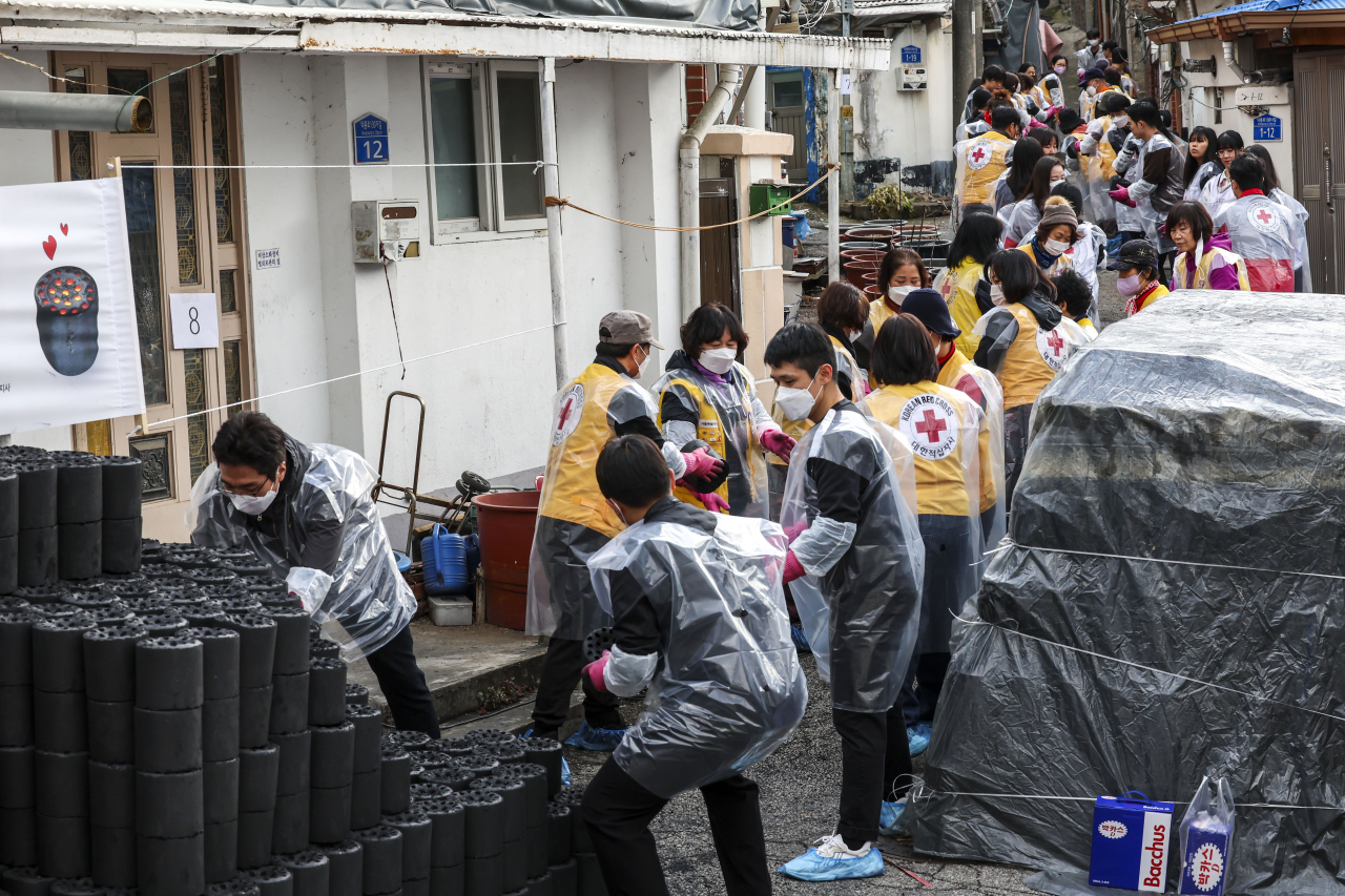 Volunteers from the Korean Red Cross and a corporate firm distribute coal briquettes for the underprivileged, Dec. 8. (Newsis)