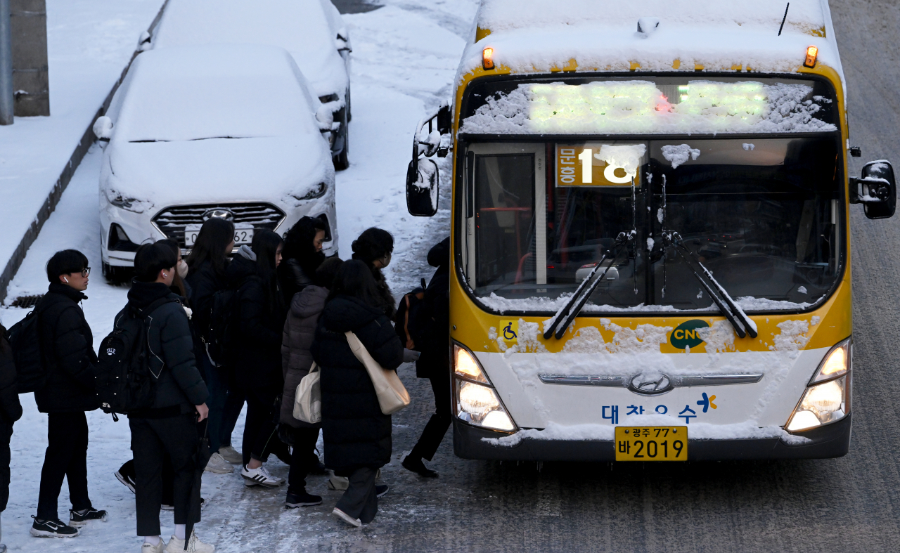 Commuters in Gwangju get on a bus Thursday morning. (Newsis)