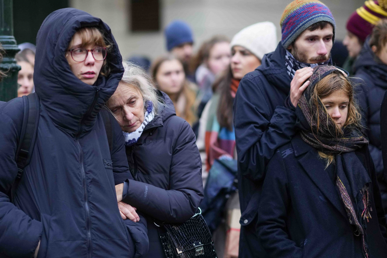 Mourners stand outside the headquarters of Charles University after mass shooting in Prague, Czech Republic, Friday, Dec. 22. A lone gunman opened fire at a university on Thursday, killing more than a dozen people and injuring scores of people. (AP)