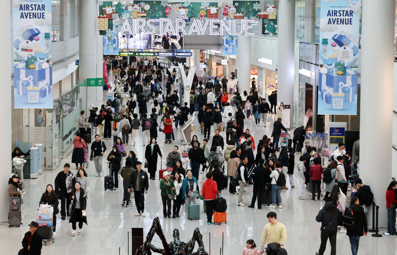 Incheon International Airport bustles with travelers ahead of the Christmas holiday on Friday. (Yonhap)