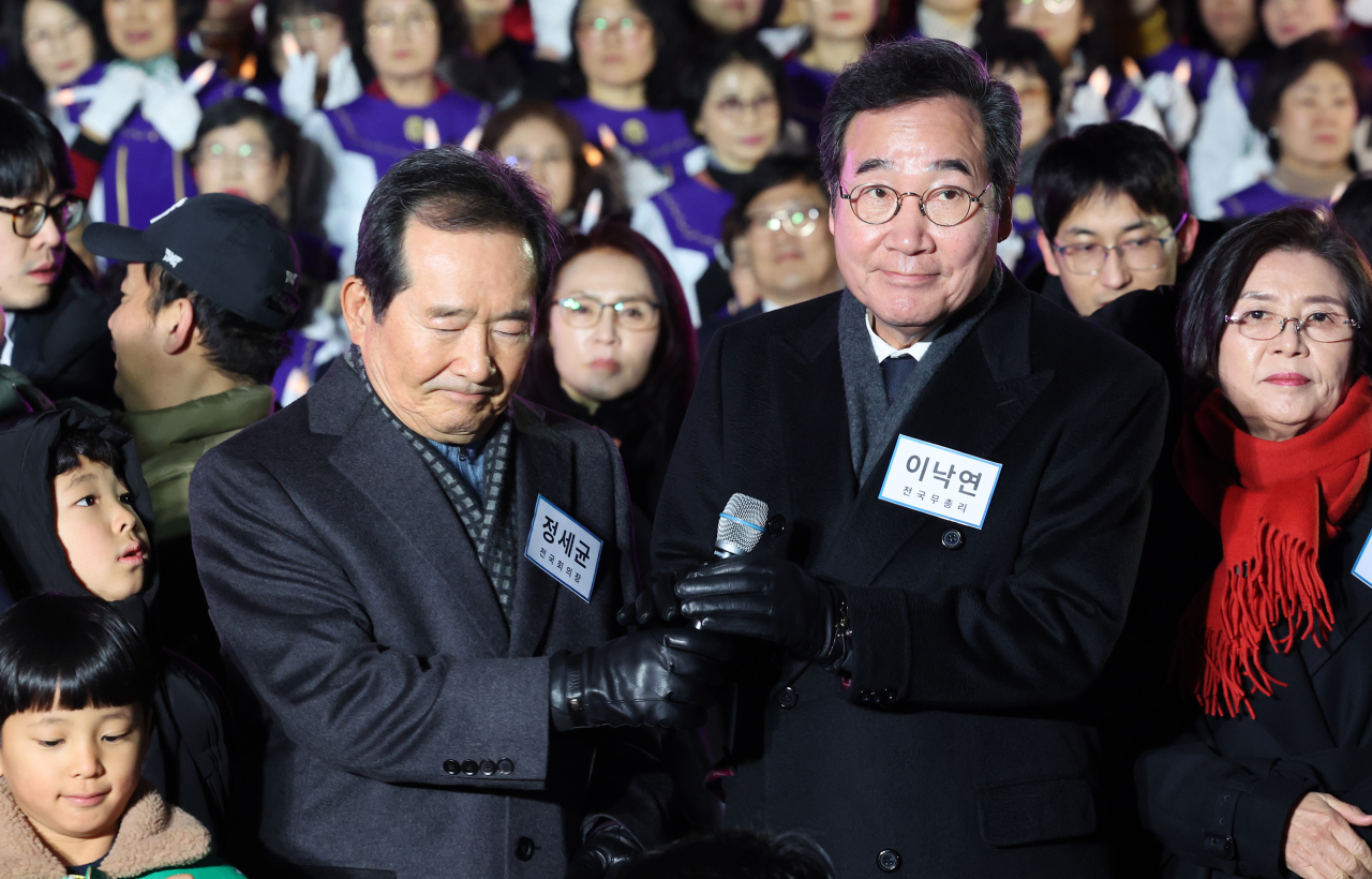 Former prime ministers Chung Se-kyun, left, and Lee Nak-yon attend a Christmas event held at Yoido Full Gospel Church in western Seoul on Sunday. (Yonhap)