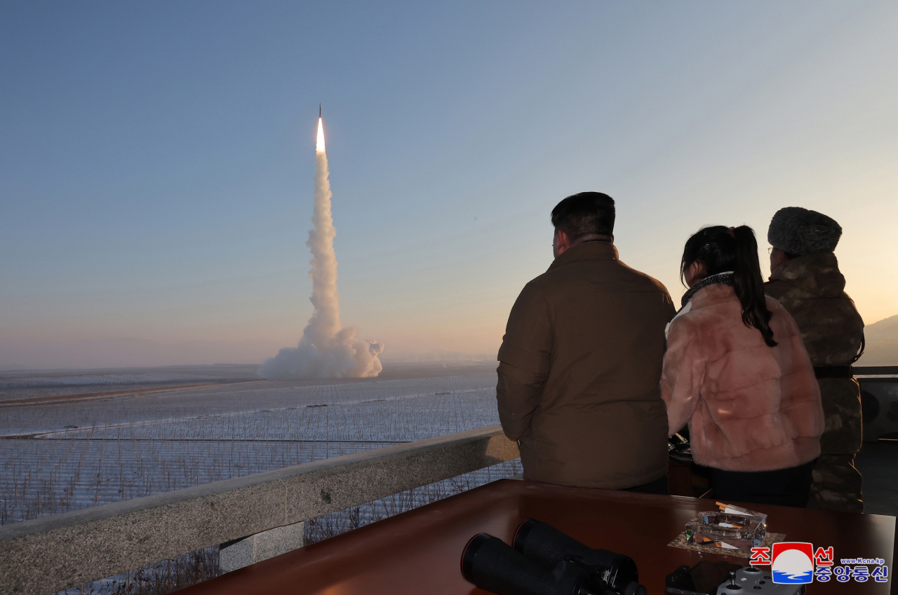 North Korean leader Kim Jong-un (left) and his daughter Ju-ae (second from left) inspect the launch of a Hwasong-18 solid-fuel intercontinental ballistic missile on Dec. 18 in this photo released by the North's official Korean Central News Agency the following day. (Yonhap)