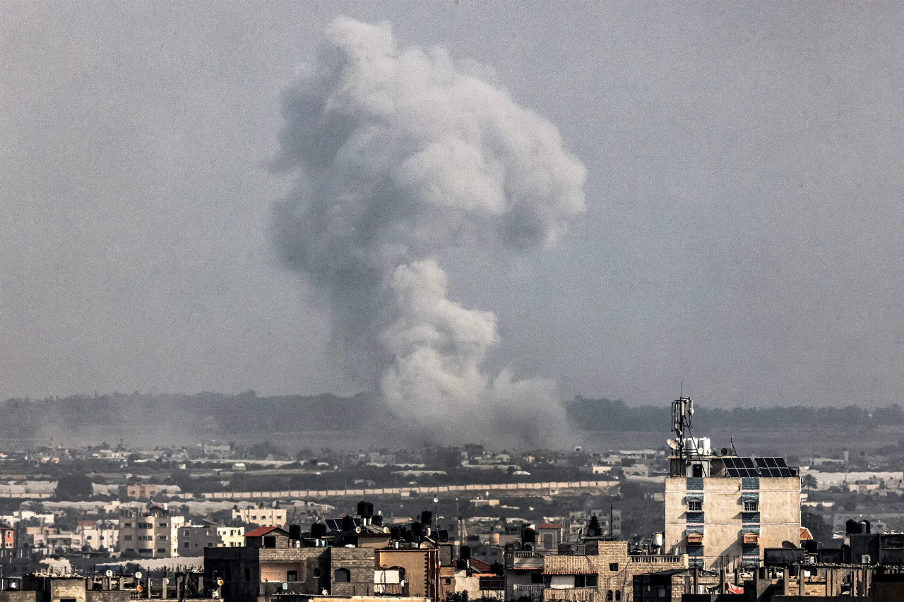 This AFP photo shows a smoke plume erupting over Khan Yunis from Rafah in the southern Gaza Strip during an Israeli bombardment on Wednesday. (Yonhap)