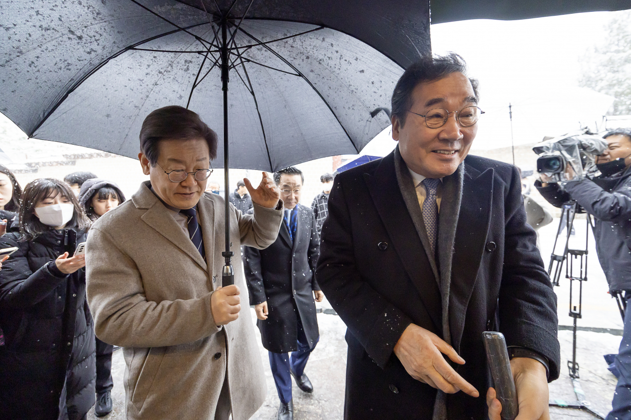 Lee Jae-myung (left), the leader of the main opposition Democratic Party, enters a restaurant with former party leader Lee Nak-yon in central Seoul, Saturday. (Yonhap)