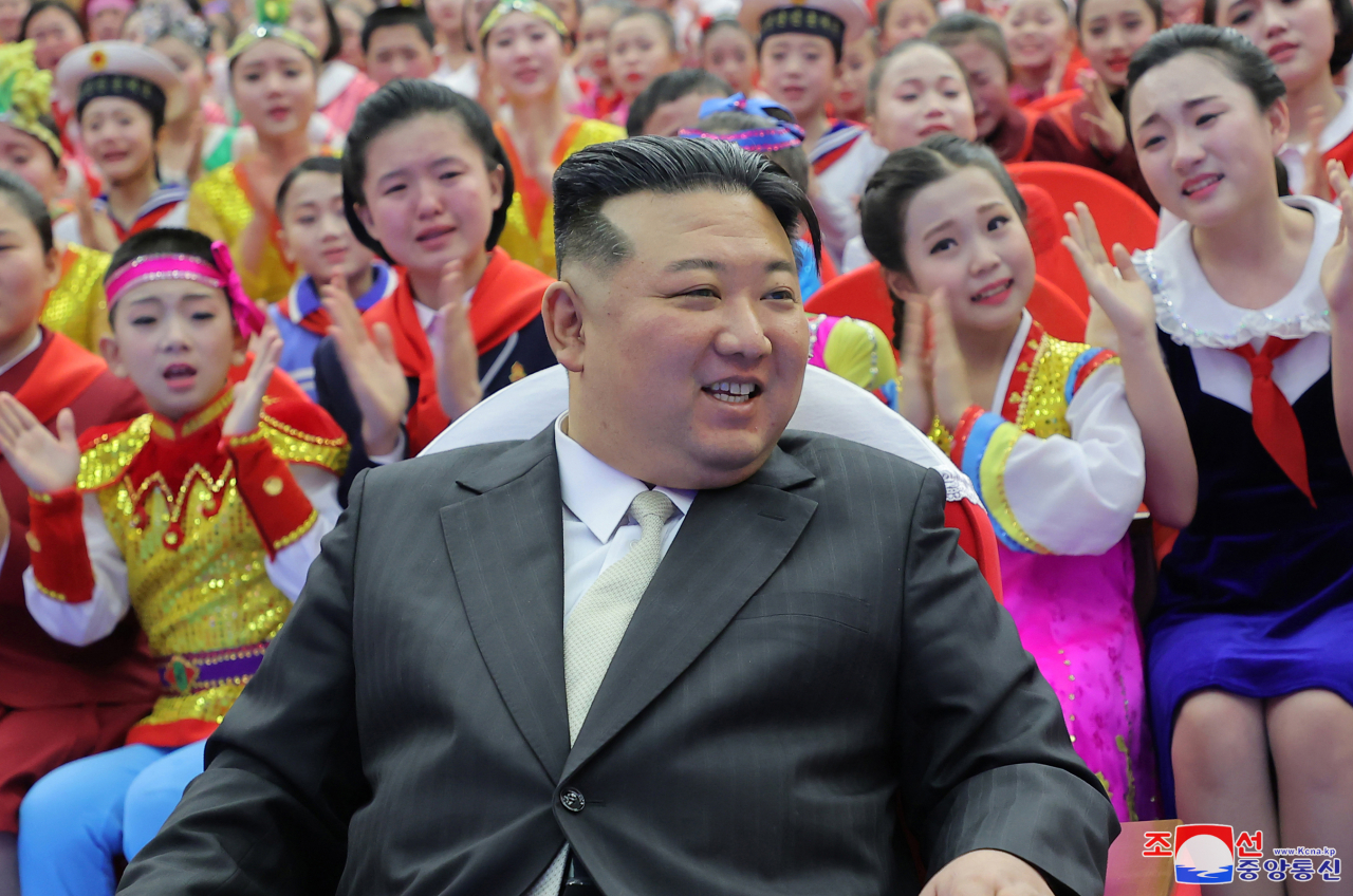 North Korean leader Kim Jong-un takes a photo with students following a New Year's Day performance at the Mangyongdae Schoolchildren's Palace on Monday. (KCNA)