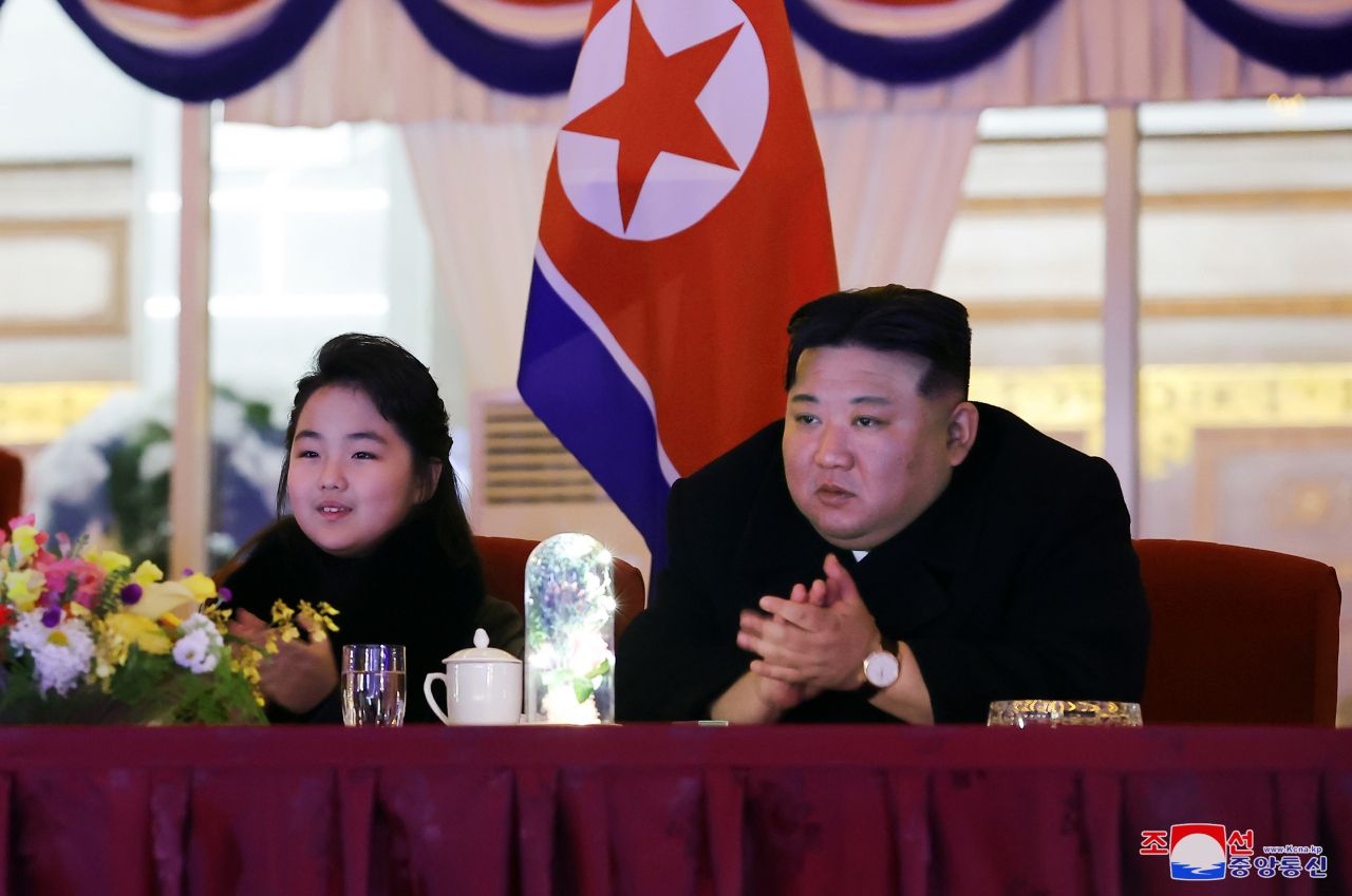 North Korean leader Kim Jong-un (right), alongside his daughter Ju-ae, applauds as he watches an art performance in a New Year’s celebration at the May Day Stadium in Pyongyang, in this undated photo released by the North’s official Korean Central News Agency on Monday. (Yonhap-KCNA)