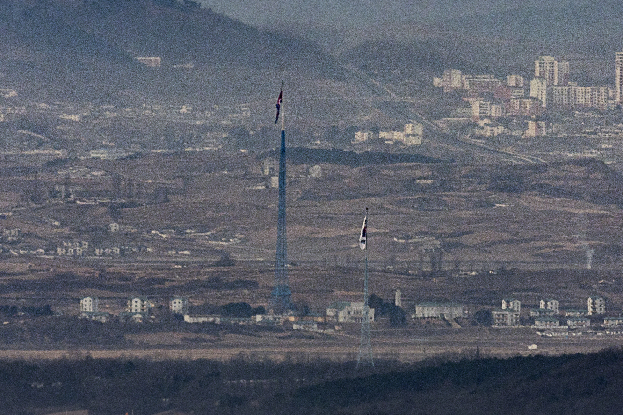 A South Korean flag in the South's Daeseong-dong and a North Korean flag in the North's Kijong-dong face each other on the western border in this photo taken from the South Korean border city of Paju on Dec. 18. (Yonhap)