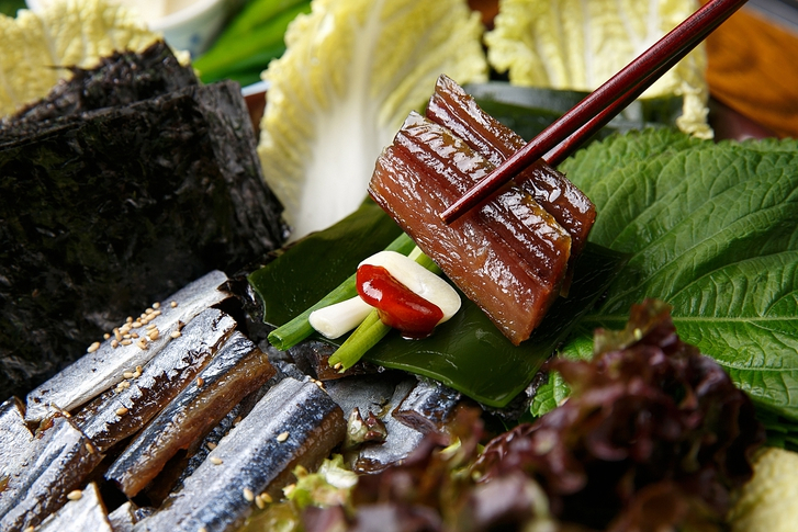 The local way to eat Gwamegi is to make a veggie wrap with gwamegi, garlic, chives, water parsley, kelp and vinegared red chile paste. (Getty Images)