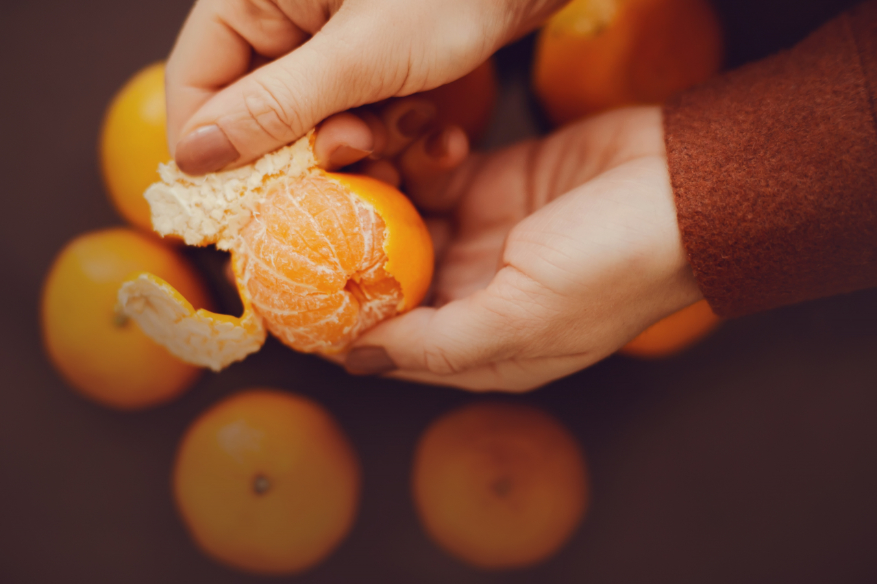 A woman peels tangerines. (123rf)