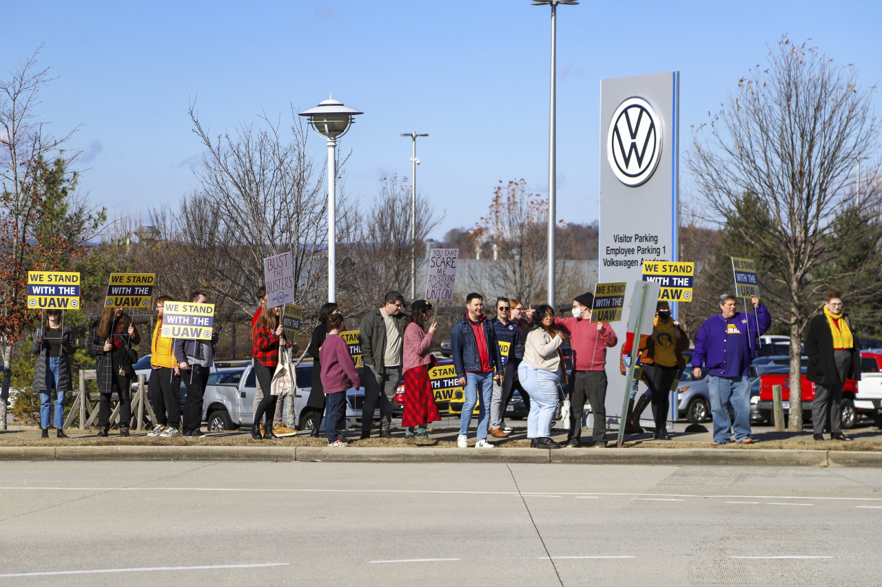A group walks away from the Volkswagen plant, holding signs in Chattanooga, Tennessee on Dec. 18, 2023. (AP)