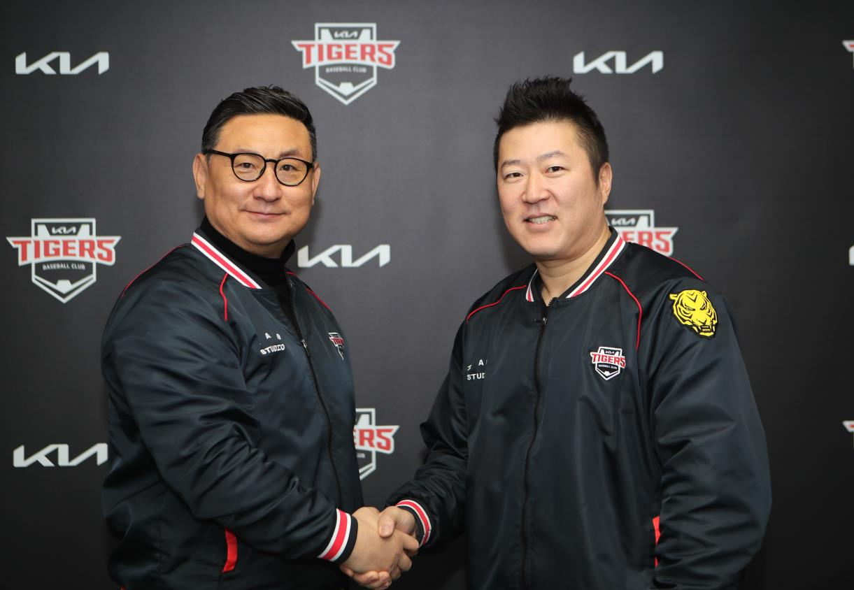 Kia Tigers designated hitter Choi Hyoung-woo (right) shakes hands with his general manager Shim Jae-hak after signing a two-year extension with the Korea Baseball Organization club on Friday. (Kia Tigers)