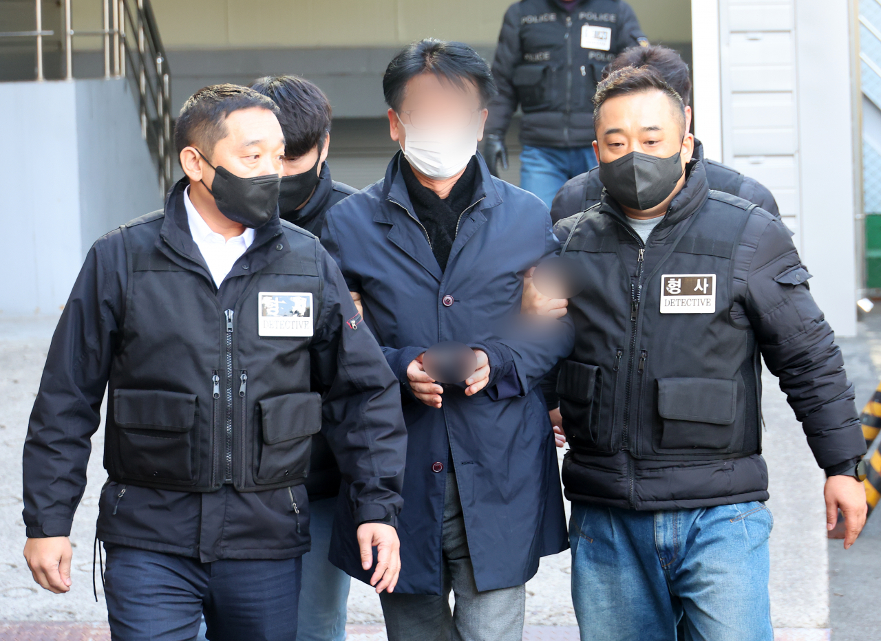The suspect in the stabbing of Democratic Party of Korea leader Lee Jae-myung is taken from the Busan Metropolitan Police Agency to attend a review of his arrest warrant at Busan District Court on Thursday. (Yonhap)