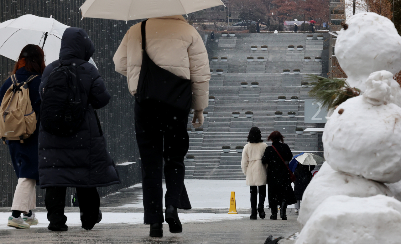 People walk around the Ewha Womans University campus in Seoul on Tuesday, as a heavy snow advisory was issued across the nation. (Yonhap)