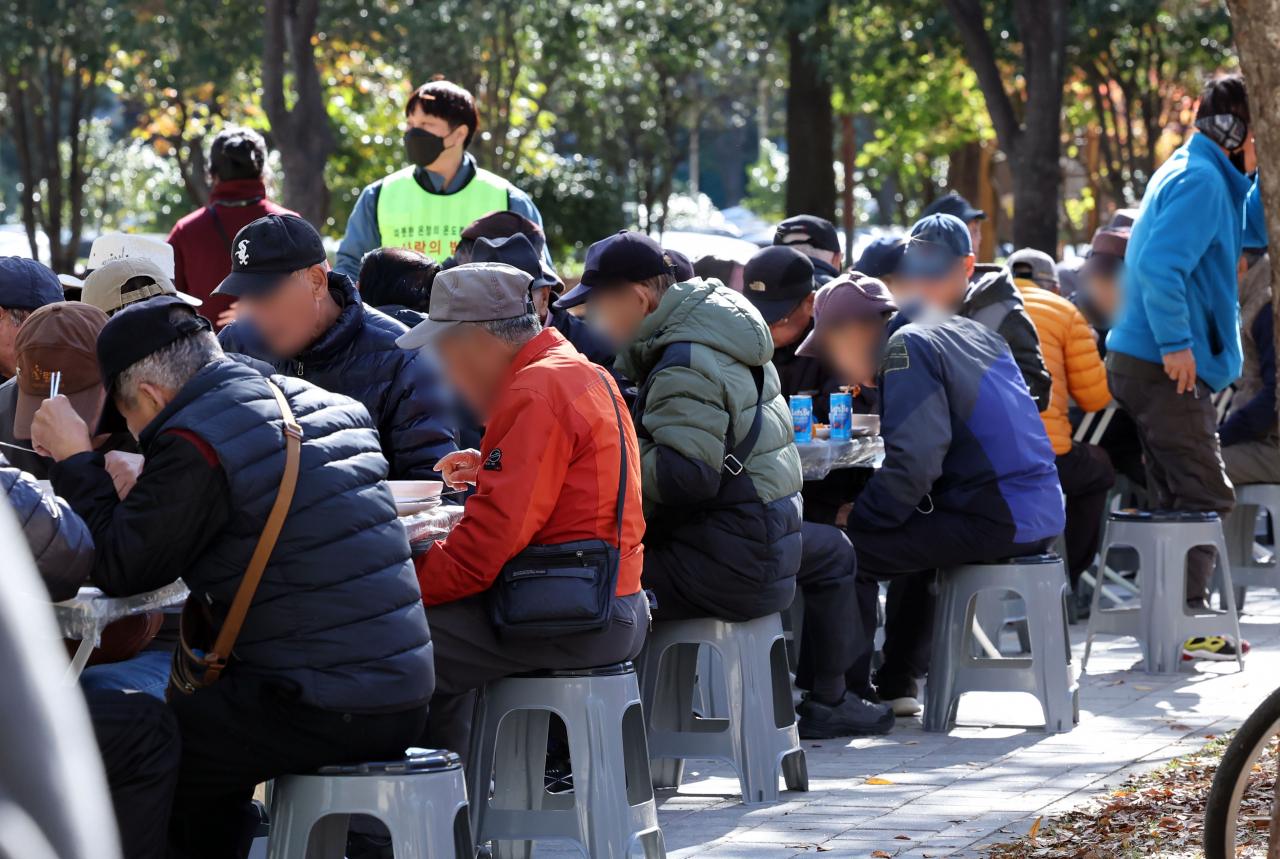 Older people eat free meals outside in Yeonje-gu, Busan, Nov. 14, 2023. (Newsis)