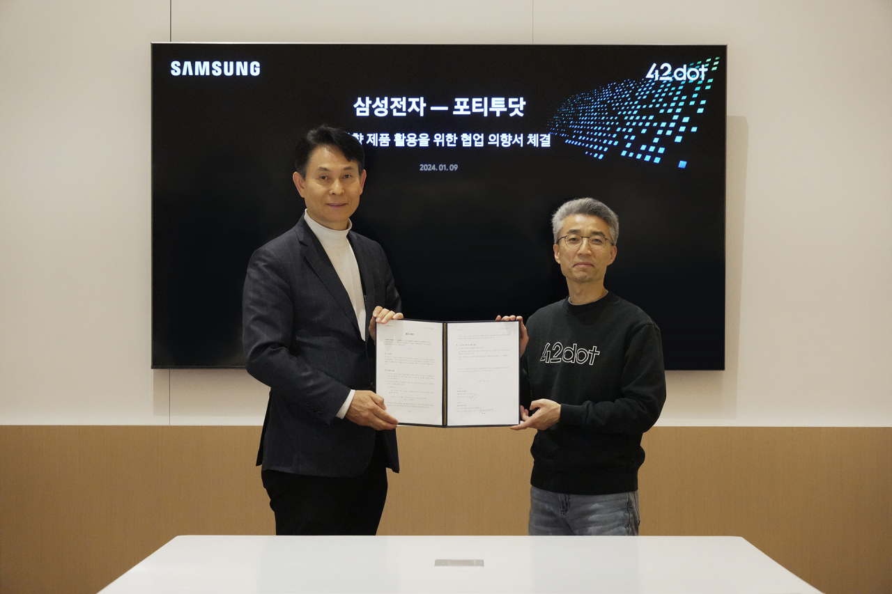 Song Chang-hyeon (right), 42dot CEO and president of the software-defined vehicle unit at Hyundai Motor Group, and Park Yong-in, president of the system large-scale integration division at Samsung Electronics, hold a signed memorandum of understanding at the CES 2024 in Las Vegas on Tuesday. (42 Dot)