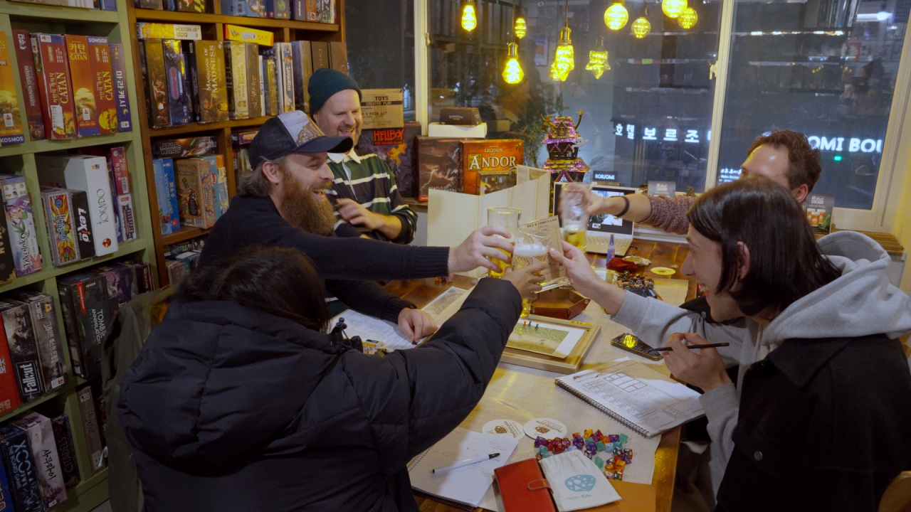 A group of players enjoys a round of Dungeons & Dragons at Dice and Comics Cafe. One of the players is participating via a video call from Japan. (The Korea Herald)