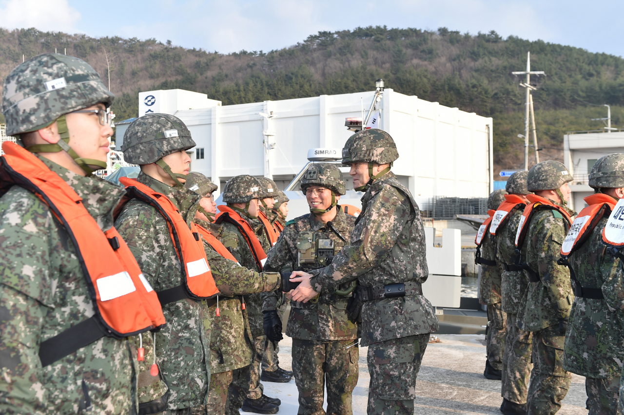 Adm. Kim Myung-soo (center), chairman of the Joint Chiefs of Staff, shakes hands with a service member at a coastal guard unit in the western county of Taean, 109 kilometers southwest of Seoul, on Thursday (JCS)