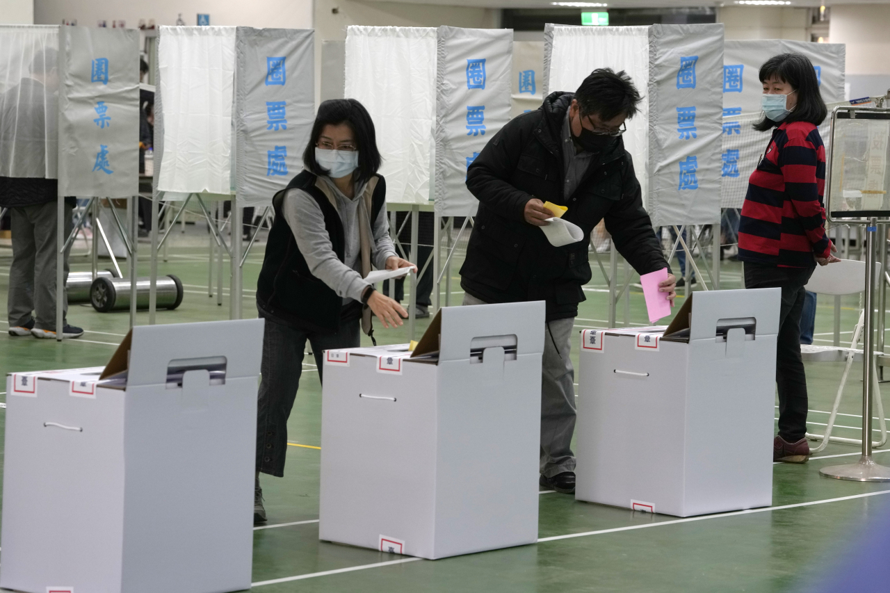 People vote for the presidential election at a polling station in southern Taiwan's Tainan city on Saturday, Jan. 13, 2024. Taiwanese are casting their votes Saturday for a new president in an election that could chart the trajectory of its relations with China over the next four years.(AP Photo/Ng Han Guan)