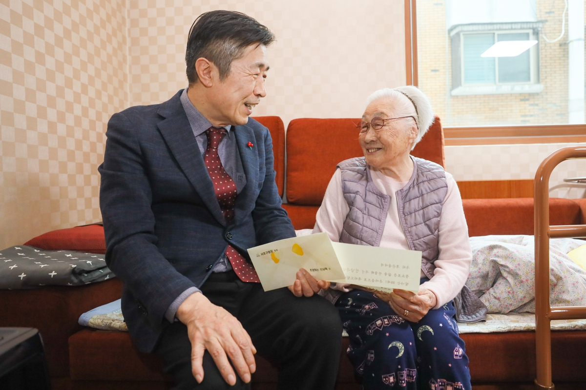Seocho-gu District Head Jun Sung-soo visits the home of a 99-year-old woman to present a congratulatory card and gift on Wednesday. (Seocho City Office)