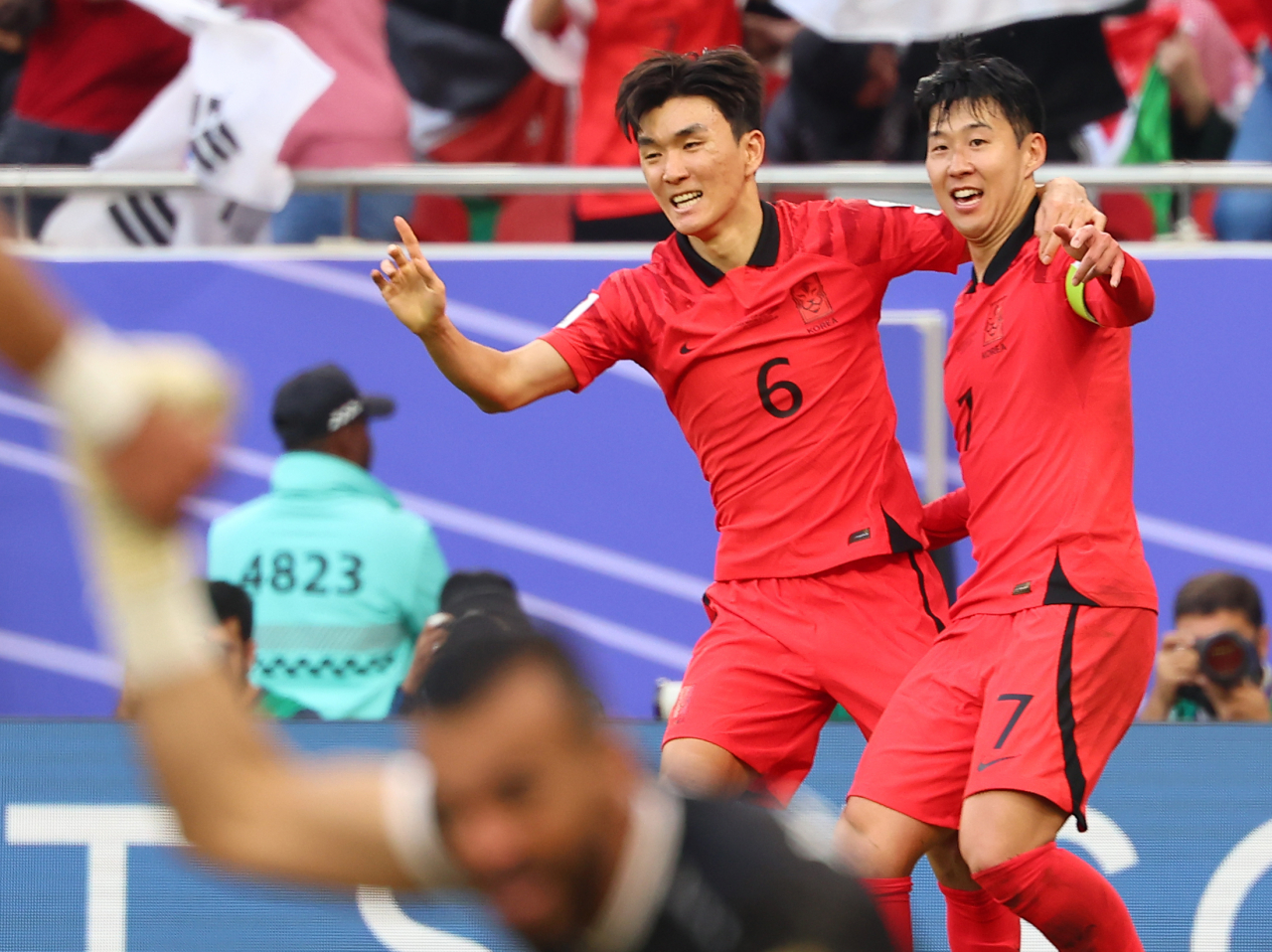 Hwang In-beom (L) and Son Heung-min of South Korea celebrate an own goal by Jordan during the teams' Group E match at the Asian Football Confederation Asian Cup at Al Thumama Stadium in Doha on Saturday. (Yonhap)