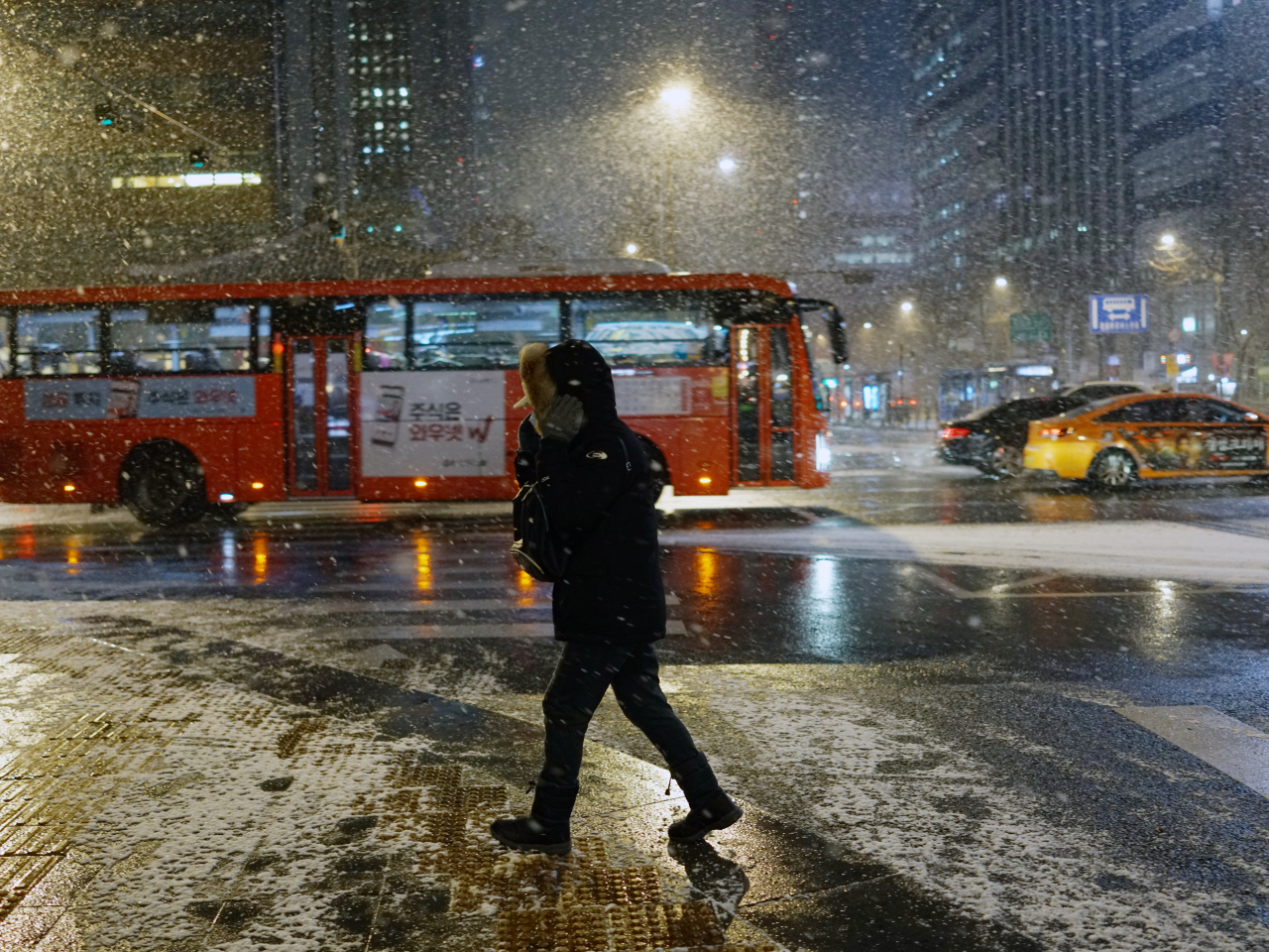 A pedestrian walks in the snow in Seoul, as many parts of the country are forecast to see snowfall amid the cold spell, Monday. (Yonhap)