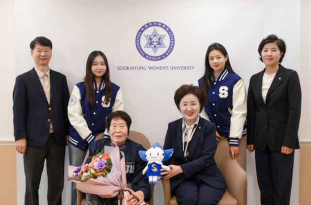 Kim Jeong-ja (front row, left) takes a photo with officials and students from Sookyung Women's University. (Sookmyung Women's University)