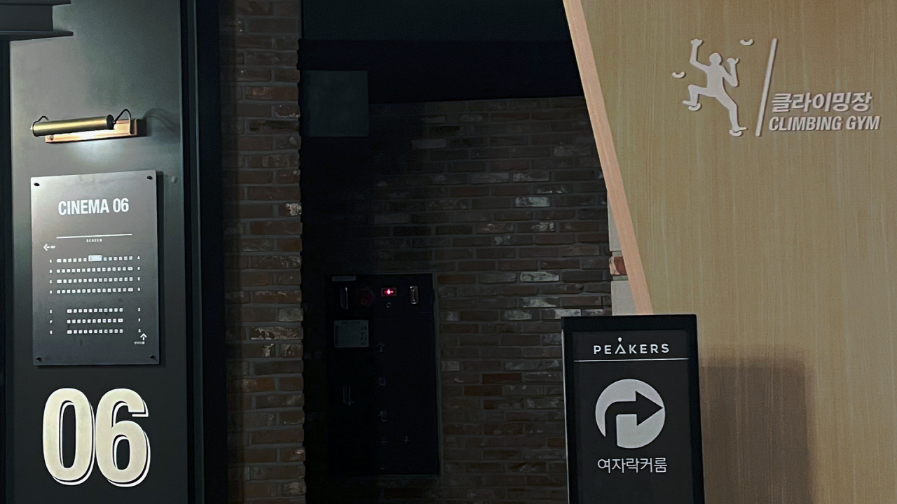 Signs for a CGV cinema and Peakers bouldering gym (Amber Anne Roos/The Korea Herald)