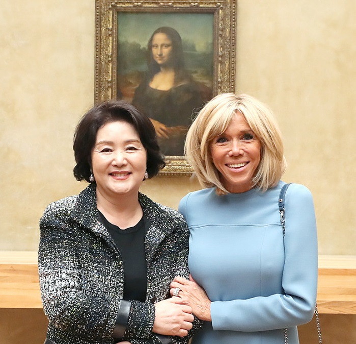 Former first lady Kim Jung-sook, left, wears the controversial custom-made Chanel jacket as she tours Louvre Museum in Paris with France's current first lady Brigitte Macron during former President Moon Jae-in's state visit to France in October 2018. (Cheong Wa Dae)