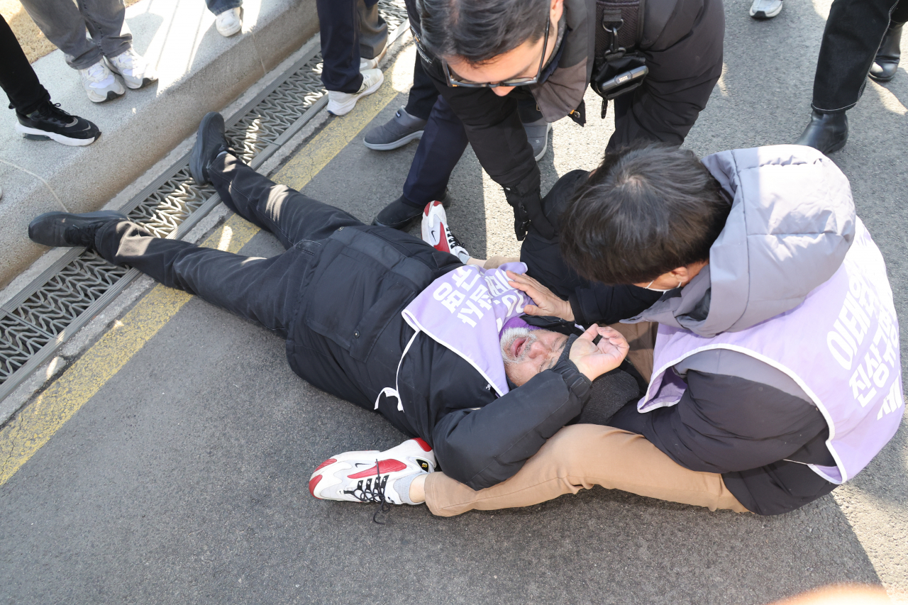A bereaved family of the 2022 Itaewon crowd crush disaster lies on a street as protest erupted in front of the Government Complex Seoul where the South Korean Cabinet asked President Yoon Suk Yeol Tuesday to veto the special bill to launch an investigation committee to carry out a renewed probe. (Yonhap)