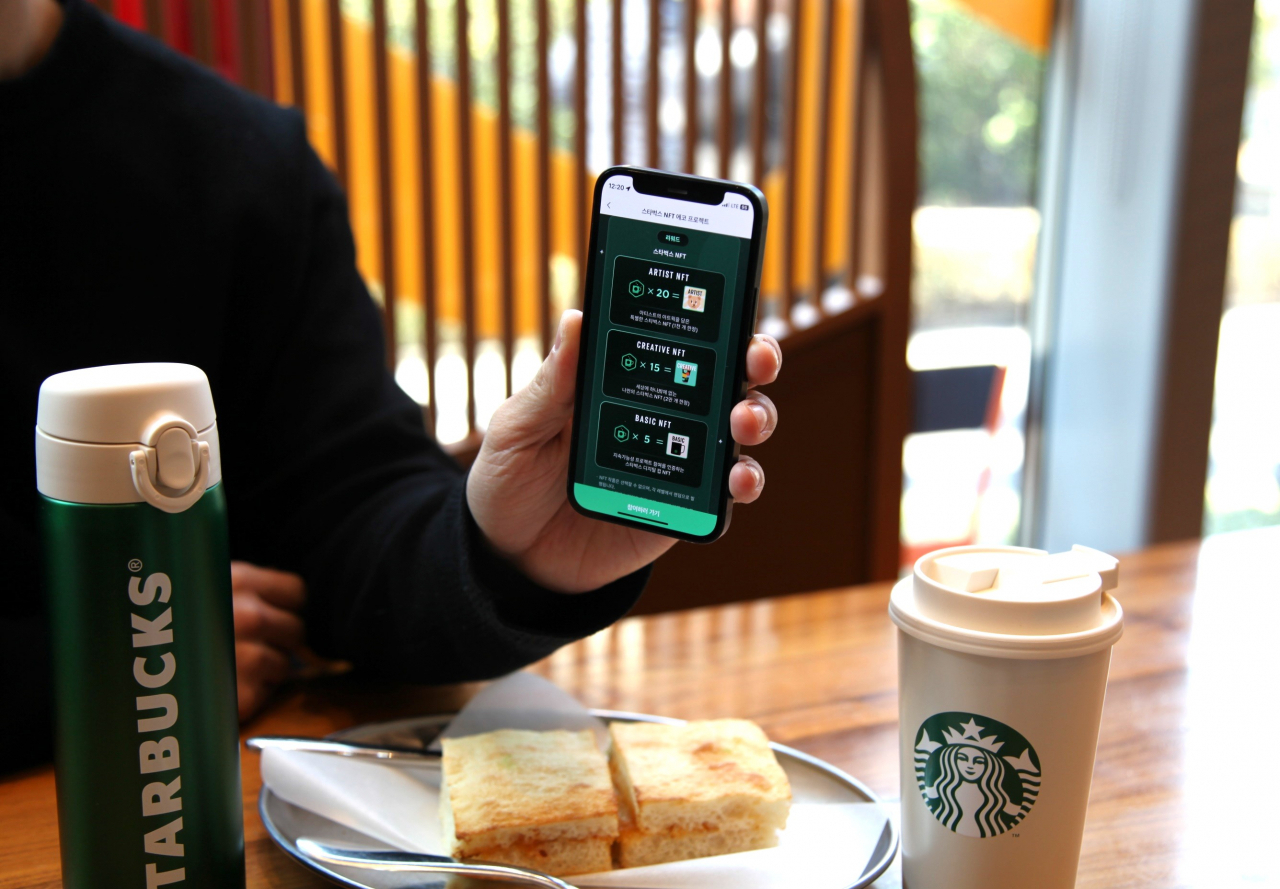 Consumer holds up the Starbucks Reward's app (Starbucks Korea)