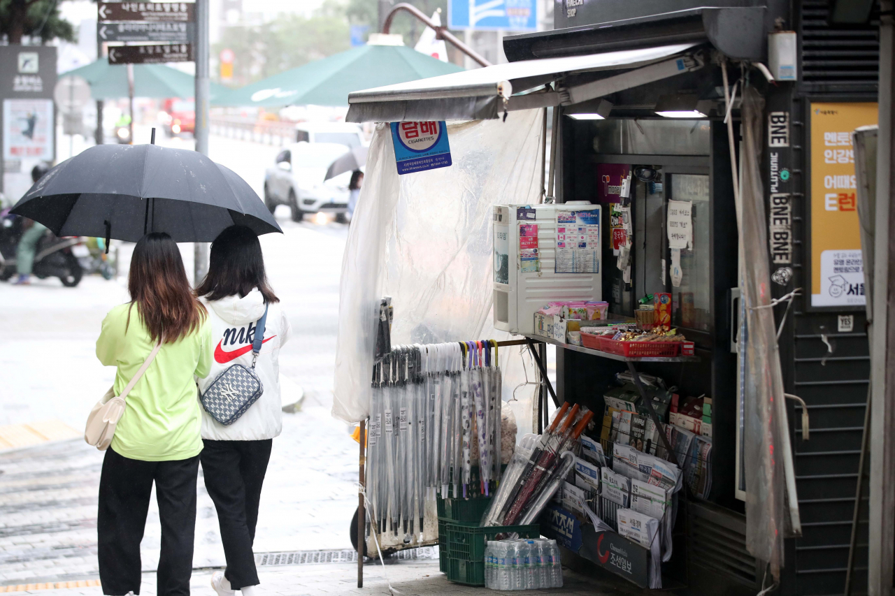 Citizens pass by a newsstand located in Seoul on Oct. 6, 2021. (Newsis)