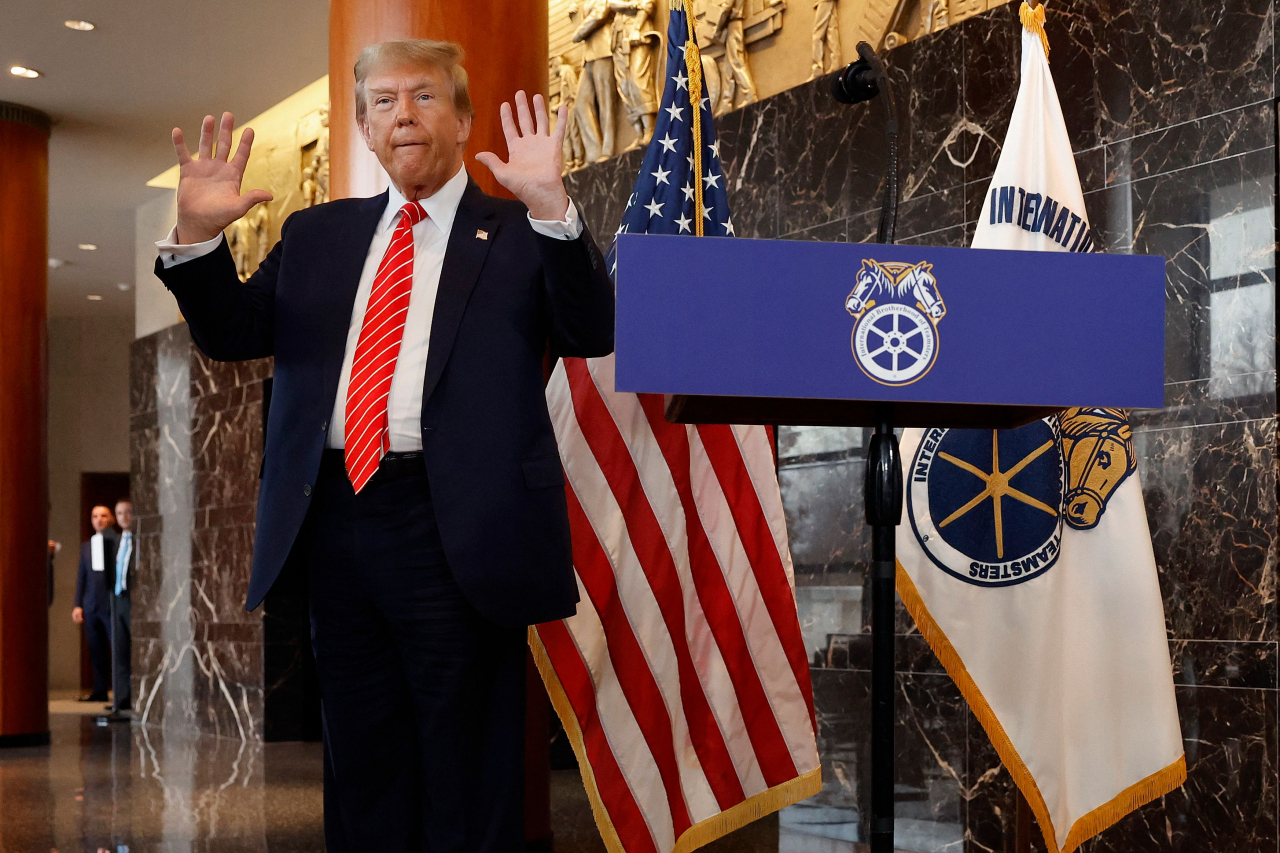 Republican presidential candidate and former US President Donald Trump holds up his hands after being asked about them by reporters at the International Brotherhood of Teamsters headquarters on Jan. 31 in Washington. (AFP-Yonhap)