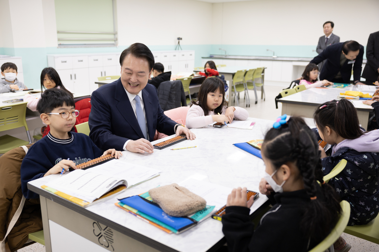 President Yoon Suk Yeol attends an abacus math class, which is part of the extracurricular program provided at the Neulbom School in Hanam, Gyeonggi Province, Monday. (Presidential office)