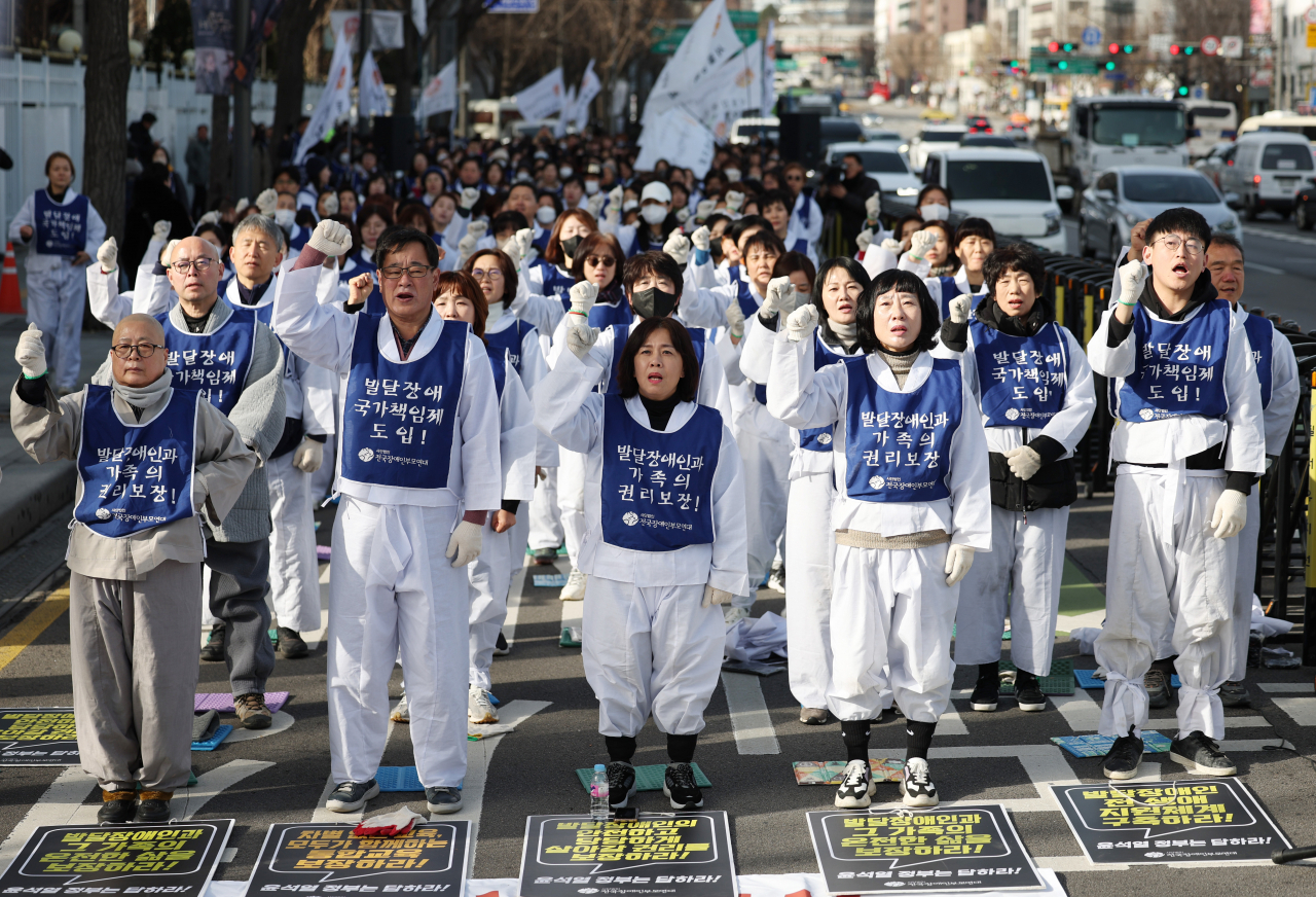 Representatives of Korea Parents’ Network for People with Disabilities demand a support system to assist people with developmental disabilities to be able to stand on their own feet during a protest in front of the Government Complex Seoul on Jan. 9. (Newsis)